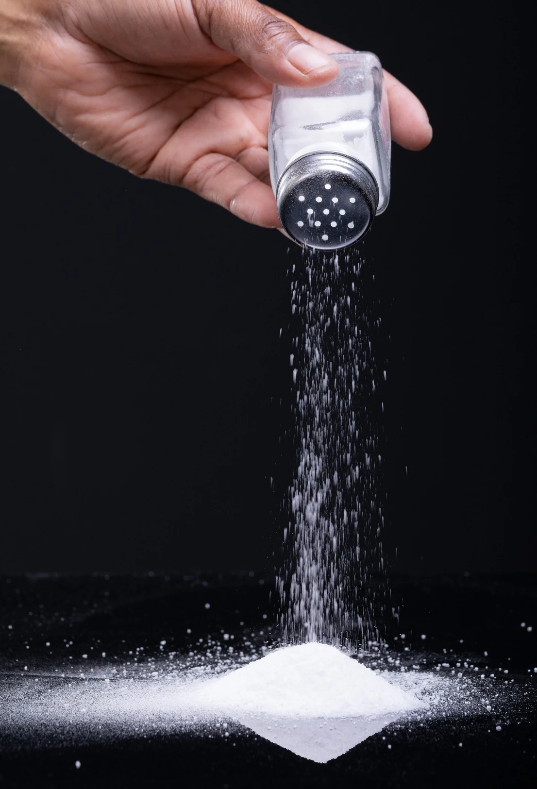 Hand pouring fine white table salt